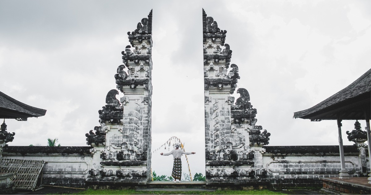 Panorama indah Bali dengan pantai berpasir putih, air laut yang jernih, dan langit cerah, memperlihatkan keindahan alam tropis yang memikat wisatawan.